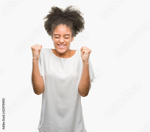 Young afro american woman over isolated background excited for success with arms raised celebrating victory smiling. Winner concept.