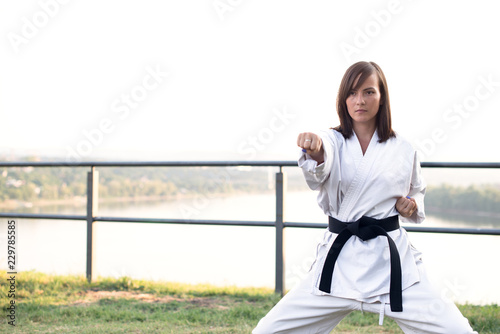 A young karate professional practicing while wearing a black belt.
