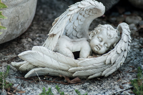 Fototapeta Zbliżenie ukamienowany anioł na grobie na cmentarzu