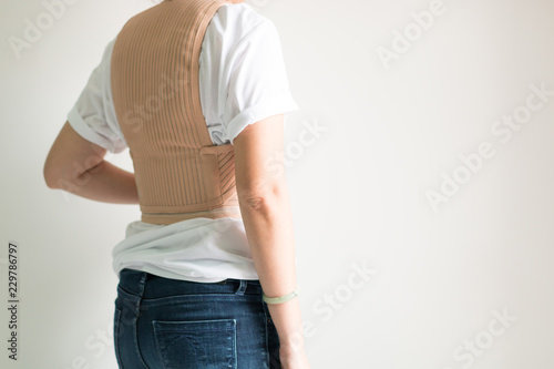 A woman wearing back support belt in healthcare concept.