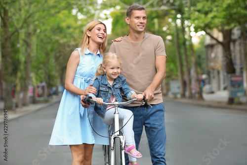 Happy family with bicycle outdoors on summer day