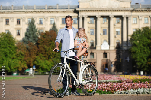 Fototapeta Naklejka Na Ścianę i Meble -  Happy father and his daughter with bicycle outdoors on sunny day