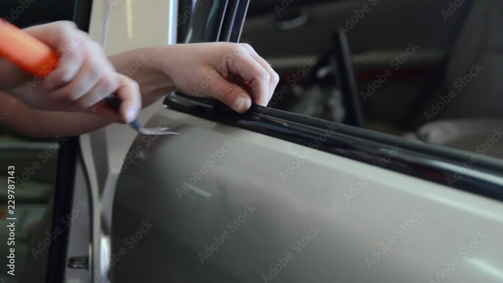 a man in a car door repairs