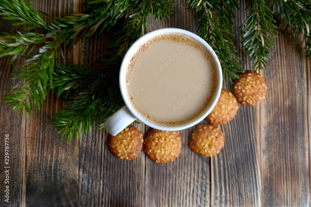 Coffee with milk, hot chocolate or cocoa with cinnamon stick in a Cup and fir branches. Winter hot drink for cold weather. New year and Christmas concept Coffee with milk, hot chocolate or cocoa with cinnamon stick in a Cup and fir branches. Winter hot drink for cold weather. New year and Christmas concept