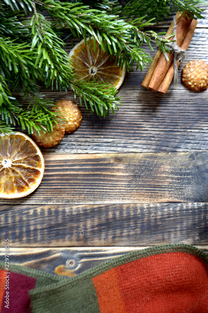 Christmas and new year background frame or card Christmas composition with fir branches dried oranges cookies cinnamon sticks and a scarf on a wooden background Christmas and new year background frame or card Christmas composition with fir branches dried oranges cookies cinnamon sticks and a scarf on a wooden background