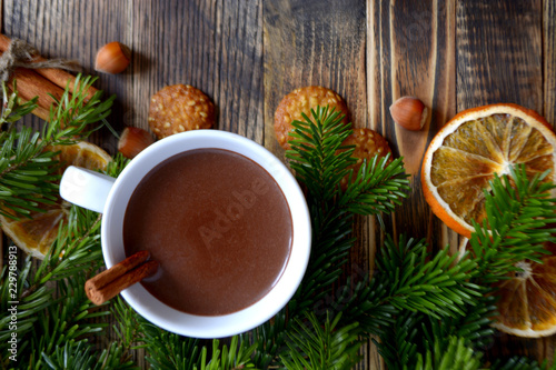 Hot chocolate or cocoa with cinnamon stick in a cup and fir branches. Winter hot drink for cold weather. New year and Christmas concept Copy space
