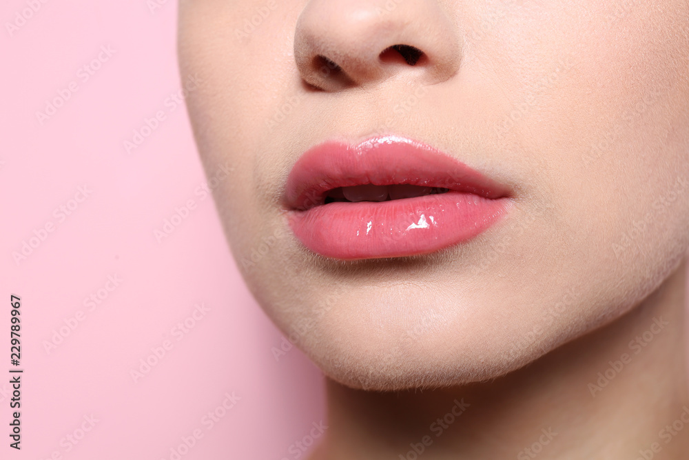 Beautiful young woman with perfect lips makeup on color background, closeup