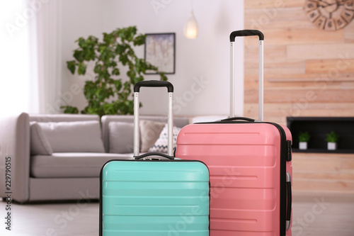 Colorful suitcases packed for journey in living room