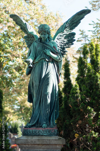 Closeup of bronze angel on tomb in cemetery