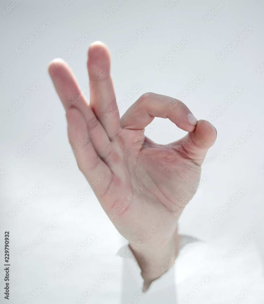 close up.male hand breaking through the paper wall and showing O close up.male hand breaking through the paper wall and showing O