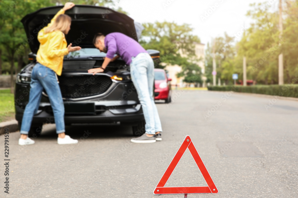 Emergency stop sign and people near broken car on background Emergency stop sign and people near broken car on background