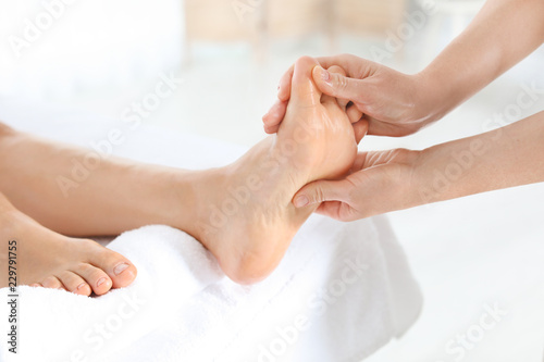 Woman receiving foot massage in wellness center, closeup