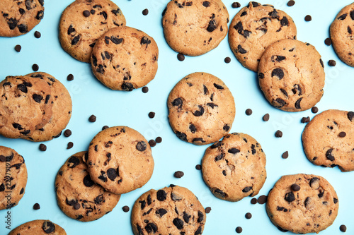 Delicious chocolate chip cookies on color background, flat lay