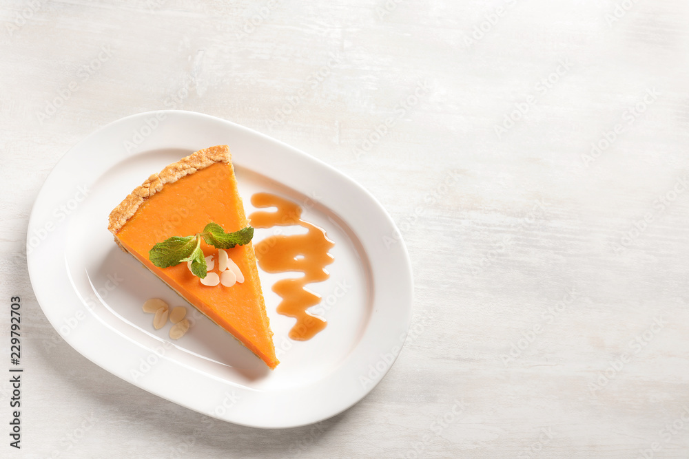 Plate with piece of fresh delicious homemade pumpkin pie on light background, top view. Space for text Plate with piece of fresh delicious homemade pumpkin pie on light background, top view. Space for text