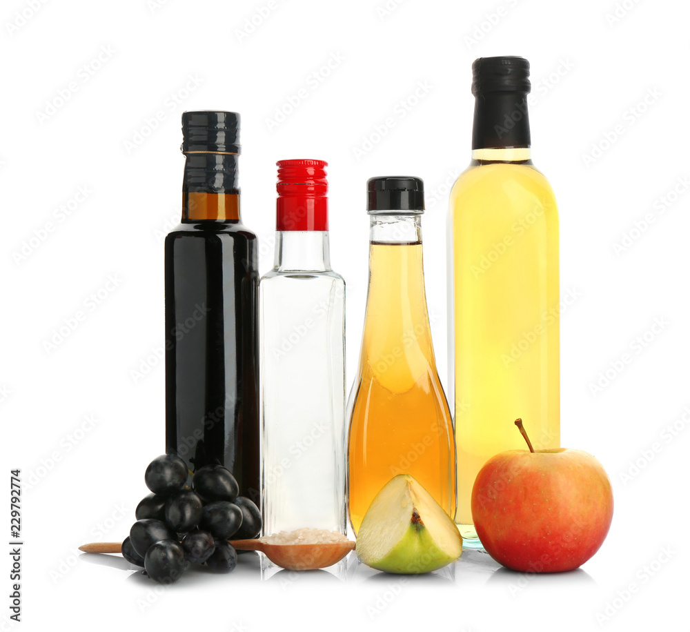 Composition with different kinds of vinegar and ingredients on white background Composition with different kinds of vinegar and ingredients on white background