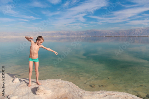 Blond cute boy playing near Dead Sea