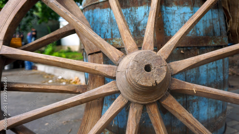 Closeup image of a vintage colored carriage wheels with blue  barrel