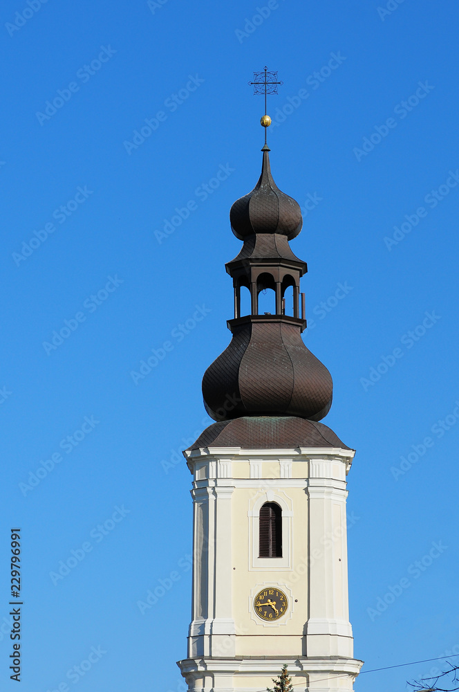 Old Polish catholic church (Church of Sts. Maurice) tower with clock on the clear blue sky. Wroclaw, Poland