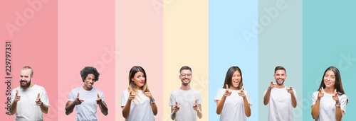 Collage of different ethnics young people wearing white t-shirt over colorful isolated background pointing fingers to camera with happy and funny face. Good energy and vibes.