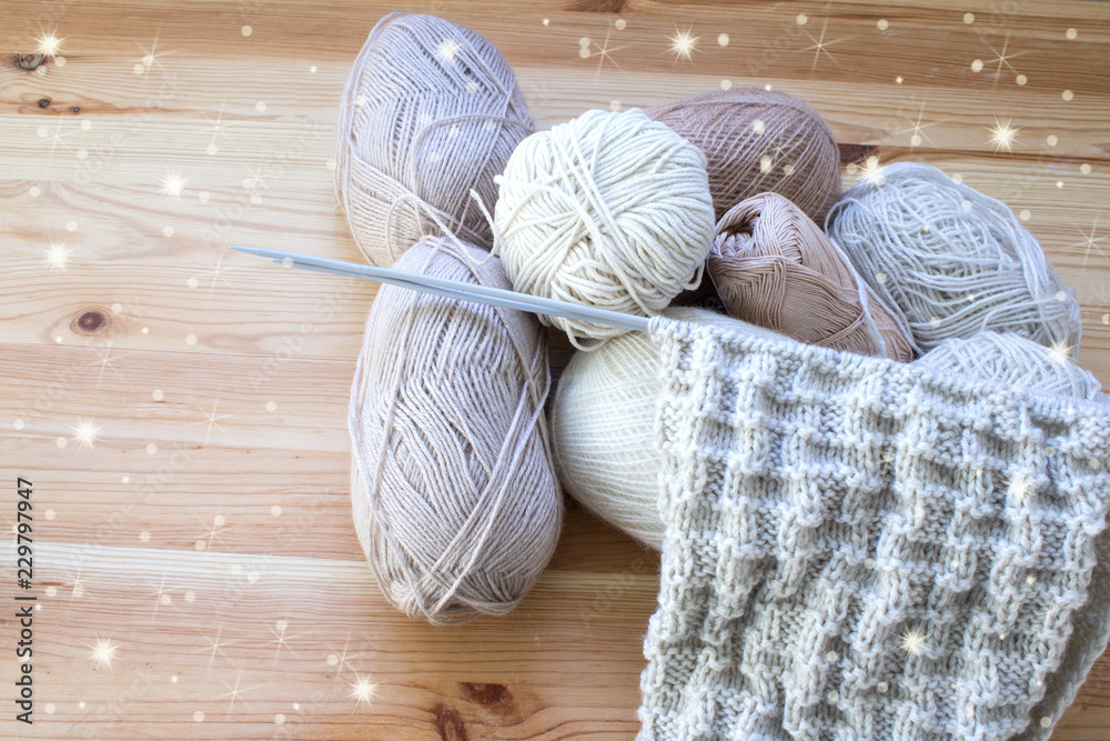 Balls of wool of natural colors on a wooden background. Copy space. Women's hobby and crafts. The concept of earning needlework. Top view Balls of wool of natural colors on a wooden background. Copy space. Women's hobby and crafts. The concept of earning needlework. Top view