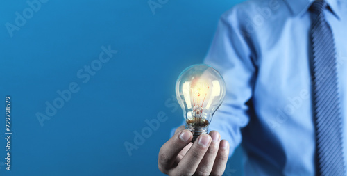 Businessman holding light bulb. Concept of new idea
