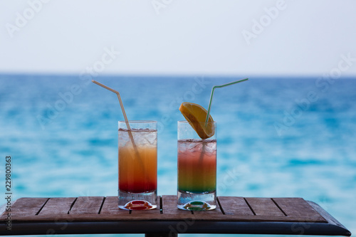 Two Colorful Tropical Cocktails on the Background of Warm Blue Sea. Happy Summer Vacation Concept.