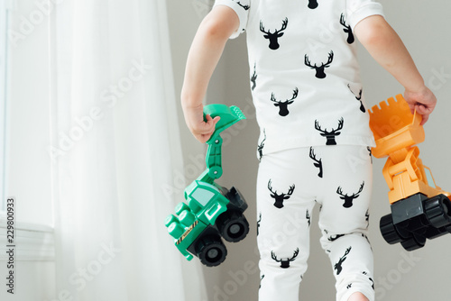 Child holding two toys