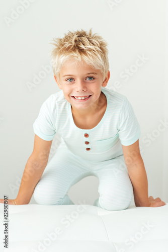 Smiling boy kneeling on a bench