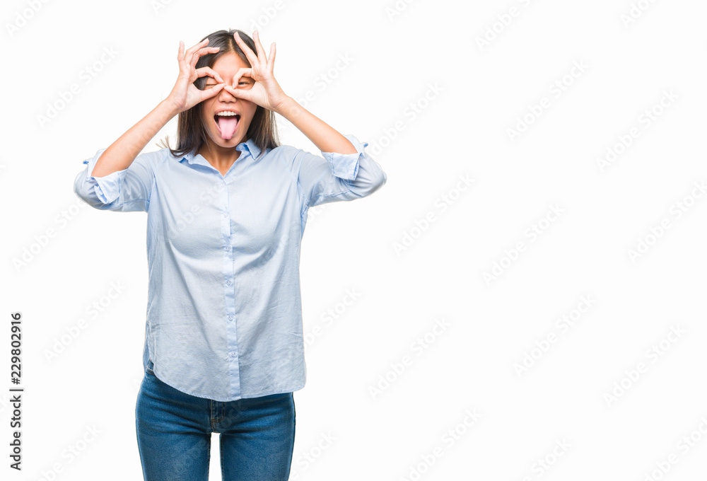 Young asian business woman over isolated background doing ok gesture like binoculars sticking tongue out, eyes looking through fingers. Crazy expression. Young asian business woman over isolated background doing ok gesture like binoculars sticking tongue out, eyes looking through fingers. Crazy expression.