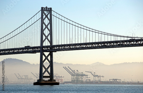 Morning view of Bay bridge with the industries in the fog, California