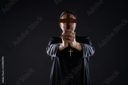 Valokuva Priest holding cross of wood praying