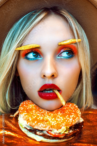Beautiful teenage girl playing with french fries