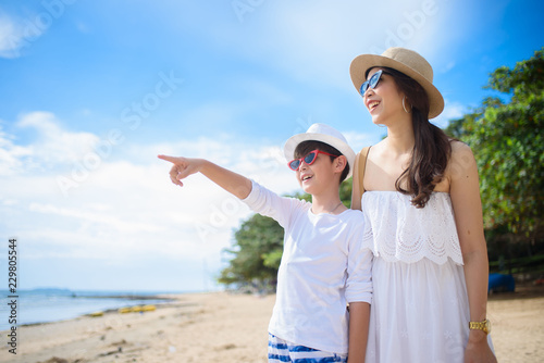  happy family mother with boy walks holding hand on the beach ,white sand beach  ,look happy in the summer