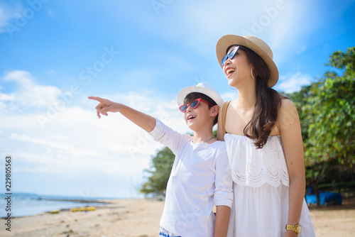  happy family mother with boy walks holding hand on the beach ,white sand beach  ,look happy in the summer