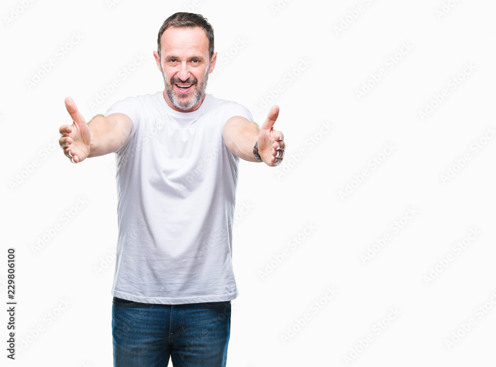 Middle age hoary senior man wearing white t-shirt over isolated background looking at the camera smiling with open arms for hug. Cheerful expression embracing happiness. Middle age hoary senior man wearing white t-shirt over isolated background looking at the camera smiling with open arms for hug. Cheerful expression embracing happiness.