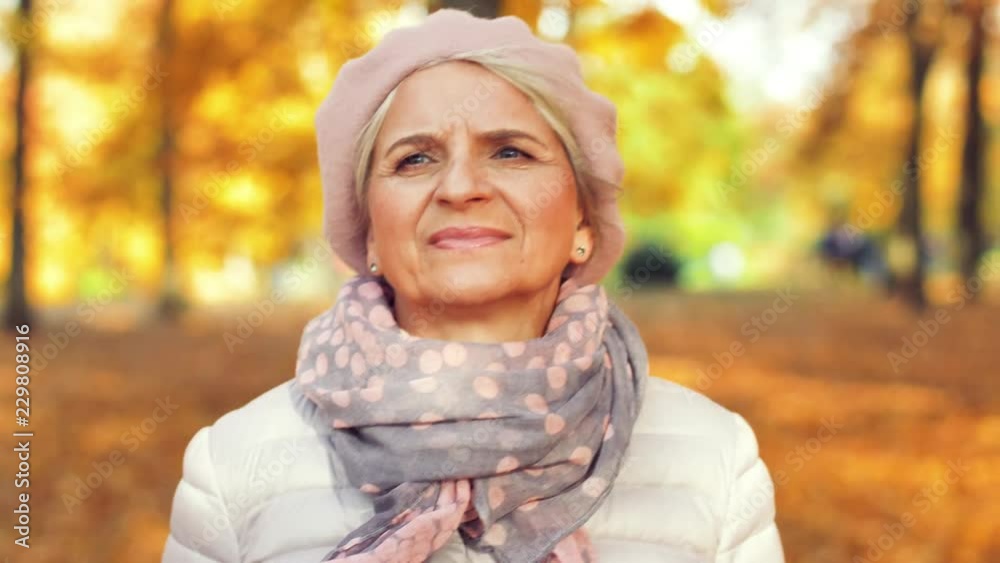 old age, retirement and season concept - happy senior woman walking along autumn park old age, retirement and season concept - happy senior woman walking along autumn park