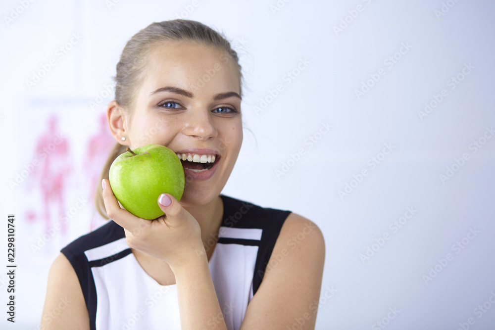 Young beautiful smiling girl with a green apple in hands Young beautiful smiling girl with a green apple in hands