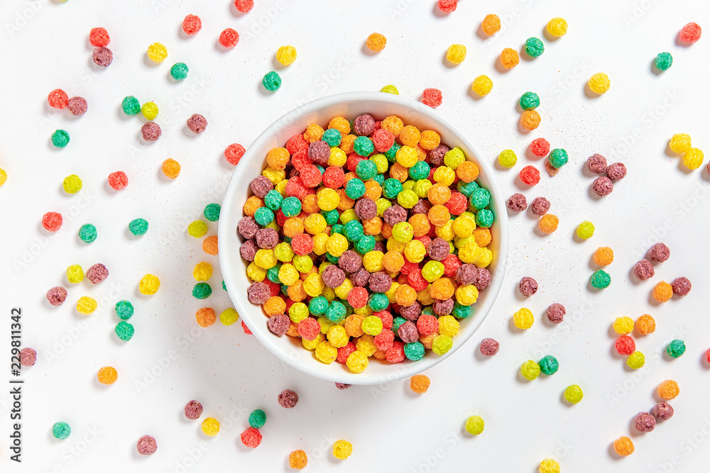 bowl of colorful cereal balls on white background. breakfast food. flat lay, top view