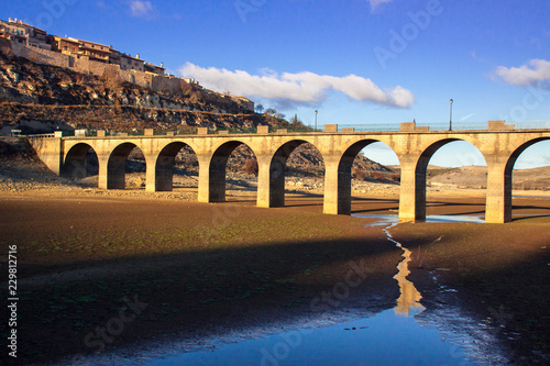 Stone bridge at sunset. Interesting shadows and lights. Drought in the Linares reservoir. Puente de Maderuelo in Segovia, Castilla y León. Spain