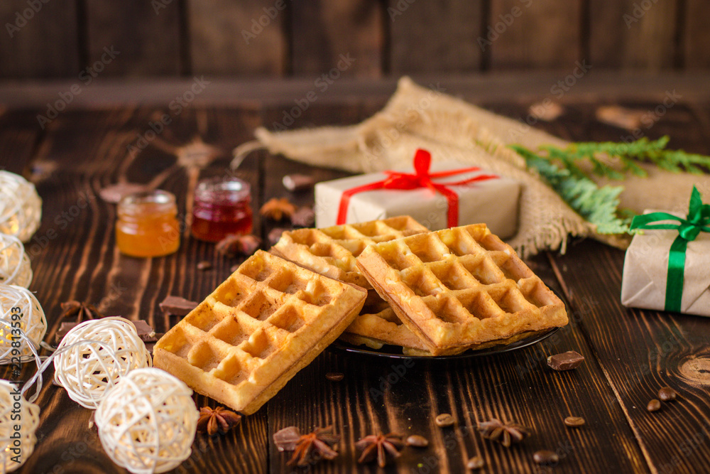 fresh belgian Tasty waffles and gifts on a wooden background. top view.