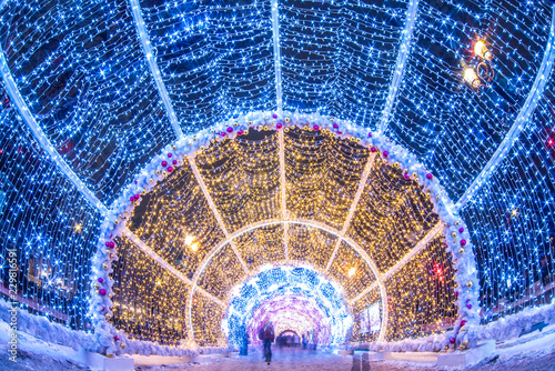 Blurred video of people passing through the New Year and Christmas holidays  light tunnels in the city center in Moscow