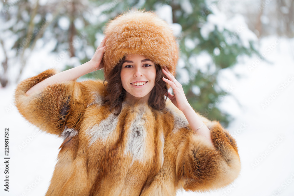Young beautiful girl in a fur hat and a red fox fur coat Young beautiful girl in a fur hat and a red fox fur coat