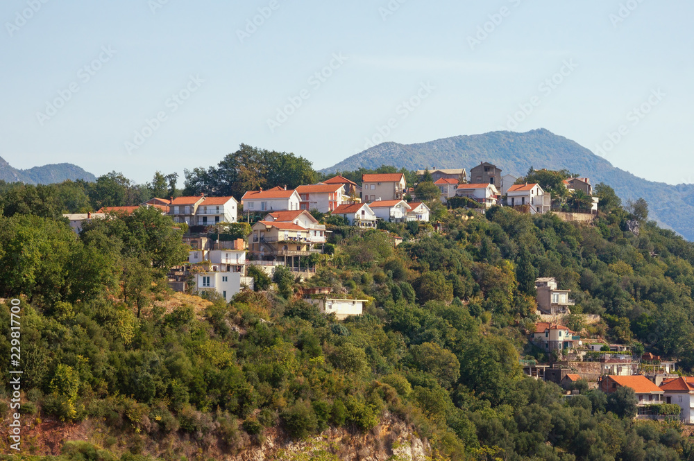 Beautiful mountain landscape with houses with red roofs on the mountainside. Montenegro, Herceg Novi