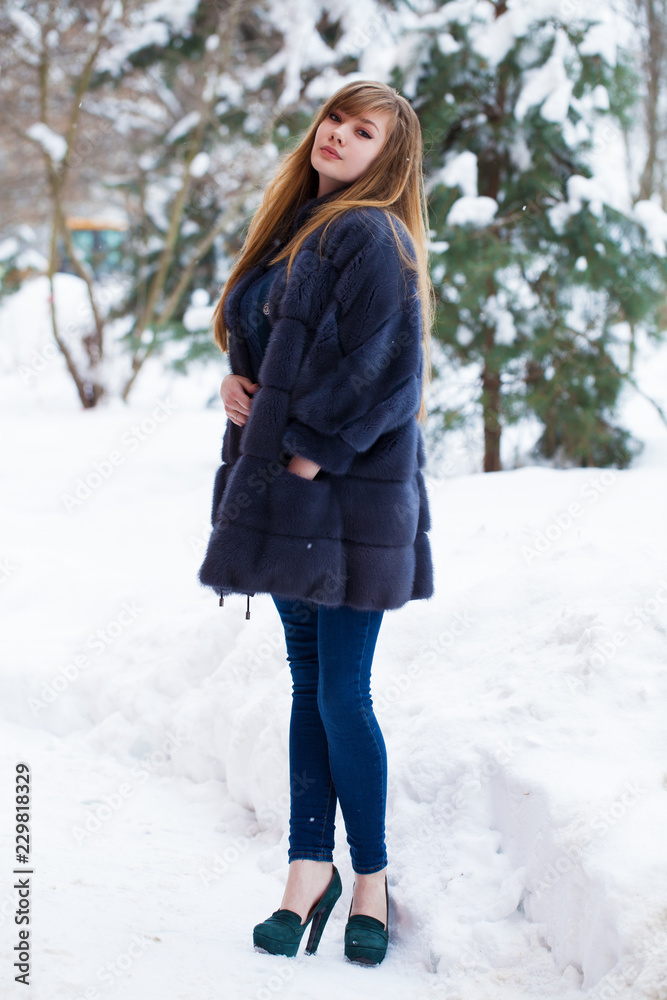 Beautiful elegant brunette woman wearing fur coat