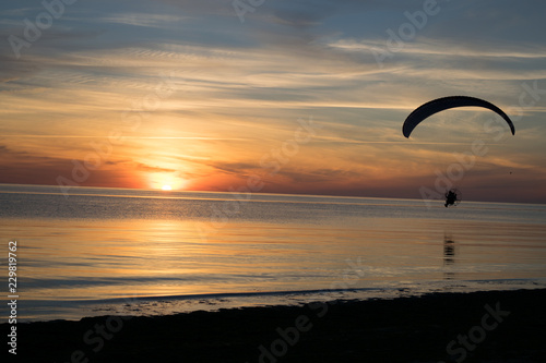 Paraglider over the sea at sunset. © metalist72
