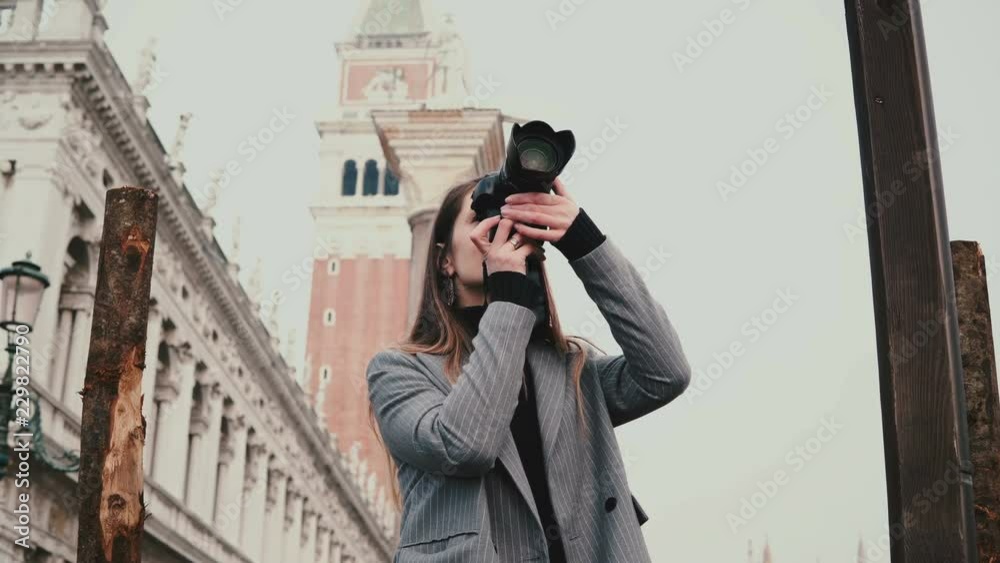 Attractive professional Caucasian journalist with camera taking photos of ancient buildings in old town of Venice Italy. Attractive professional Caucasian journalist with camera taking photos of ancient buildings in old town of Venice Italy.