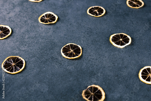 Dried sliced lemon on dark texture surface. Macro shot of fruits. © Michael Sapryhin