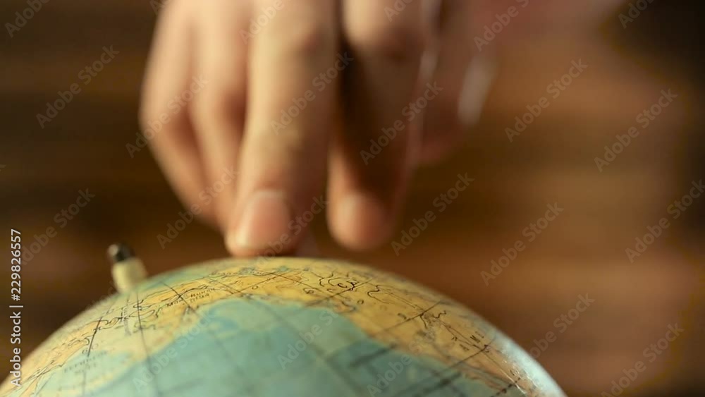 Men's fingers go on the globe
