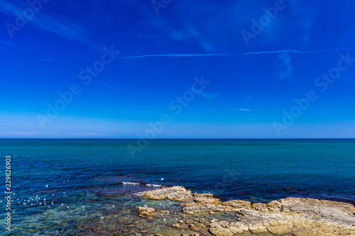 view of the sea, in the city of Trani, with the Monastery of Santa Maria di Colonna in the background. In Puglia, near Bari, Barletta, Andria. Sea and blue sky, slightly cloudy. photo