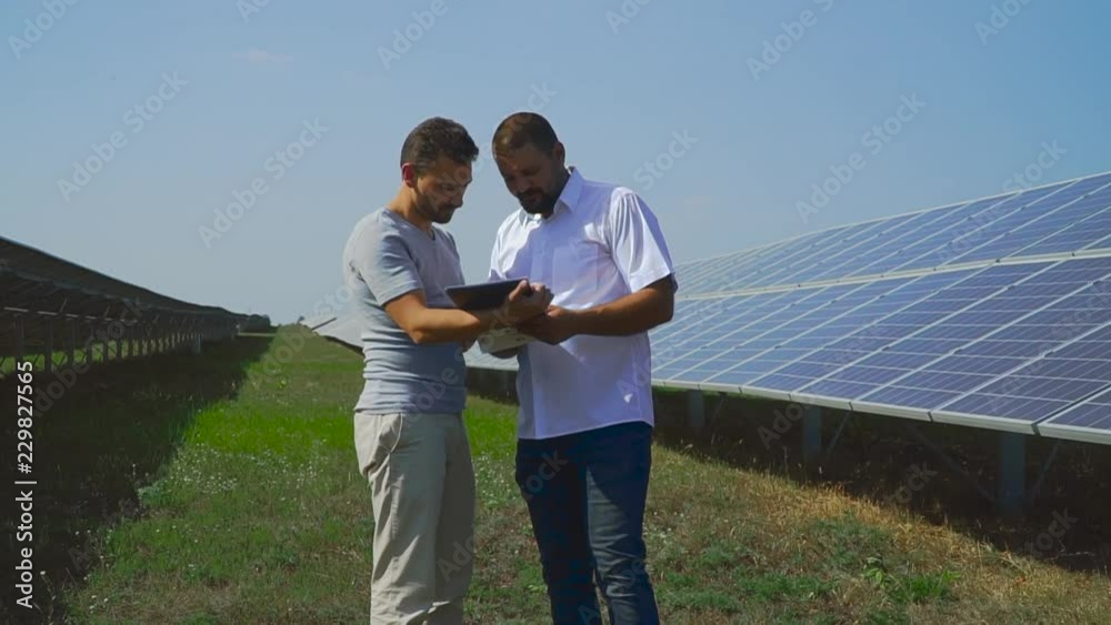 Businessman looks documents on solar batteries Businessman looks documents on solar batteries